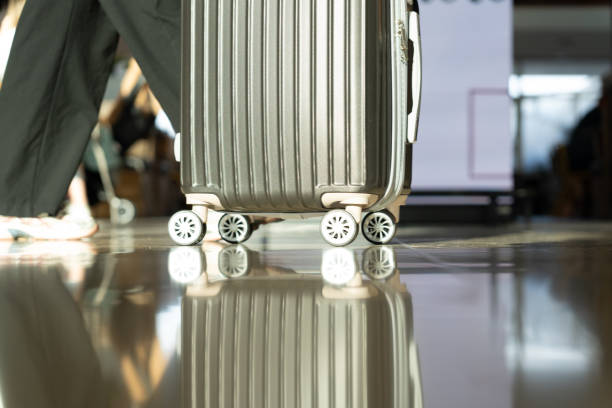 istock A solitary traveler pulls a bright silver suitcase through a busting airport terminal, symbolizing the endless possibility 2191539549