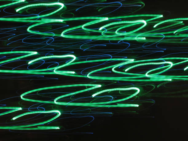 A captivating display of swirling green and blue light creates an abstract backdrop, inviting viewers into a mesmerizing dance of colors and shapes. The interplay of shades evokes energy and motion.