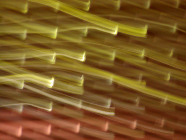 Waves of light in hues of yellow and red intertwine, creating a mesmerizing abstract background. The dynamic flow evokes a sense of motion and artistic expression in vivid colors.