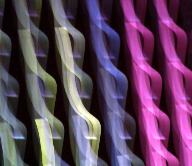 A mesmerizing display of flowing colors intertwines gracefully against a dark backdrop, evoking a sense of movement and vibrancy. The soft, blurred lines suggest dynamic energy and rhythm.