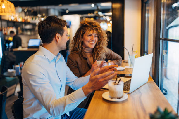 istock Two concentrated business colleagues working remotely from coffee shop. They are using a laptop and discussing a business project over coffee 2191540962