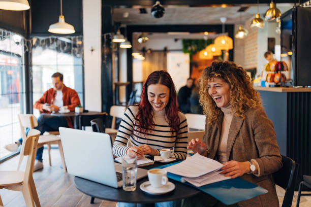 istock Smiling red-haired business woman writing down notes while working with her business colleague from the coffee shop 2191542072