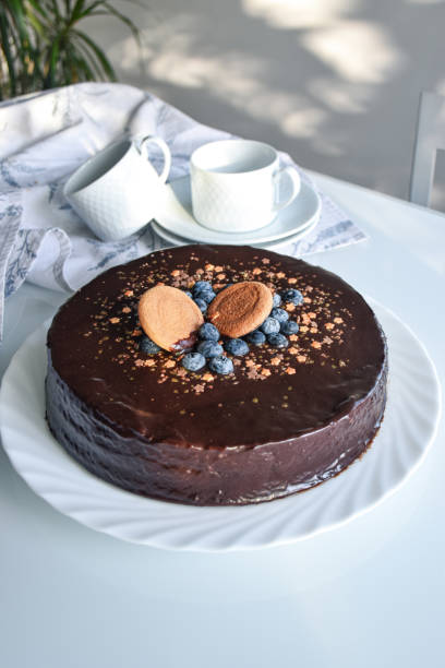 istock chocolate sacher cake decorated for party. neutral white background with kitchen elements. homemade chocolate cake. 2191544120