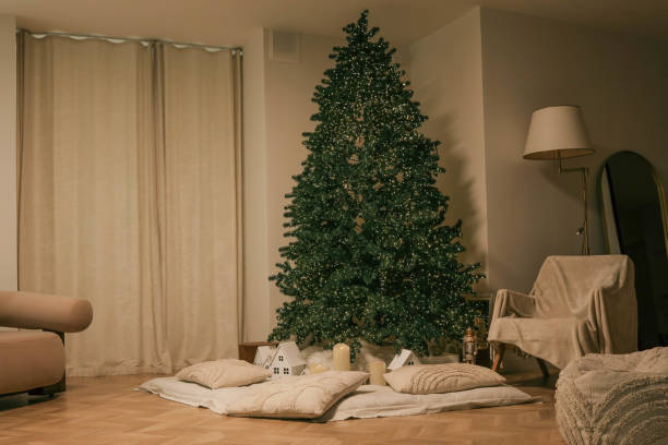 istock Minimalistic Christmas interior with a lit Christmas tree, soft pillows, glowing candles, and small decorative houses, creating a cozy and festive atmosphere 2191545098