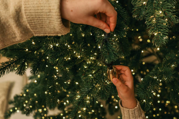 istock Parent and child decorating a Christmas tree together, holding hands while hanging an ornament. A warm and emotional family moment captured during the holiday season 2191545102