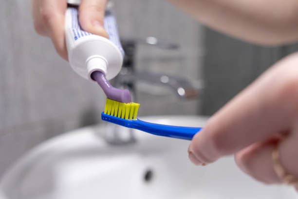 istock Applying toothpaste on a toothbrush over a bathroom sink for morning oral hygiene routine 2191546072