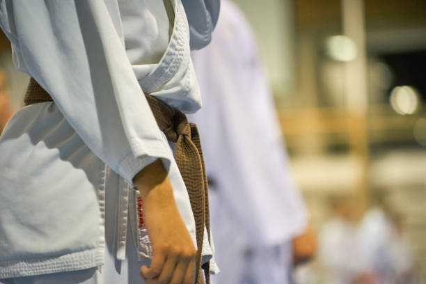 Close-up of a Karate student in a white uniform with a brown belt during training