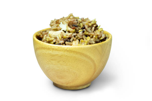 A wooden cup of cooked mixed brow n rice, rice berry, whole oat and white bean (white kidney bean) isolated on white background close up