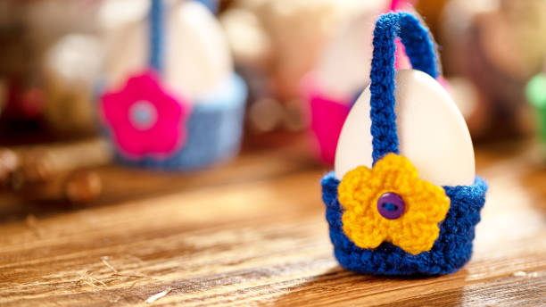 Egg in blue crochet basket with yellow flower decoration