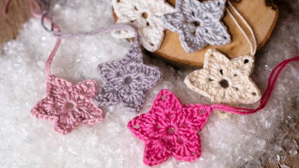 Crochet stars in pastel hues on snowy surface
