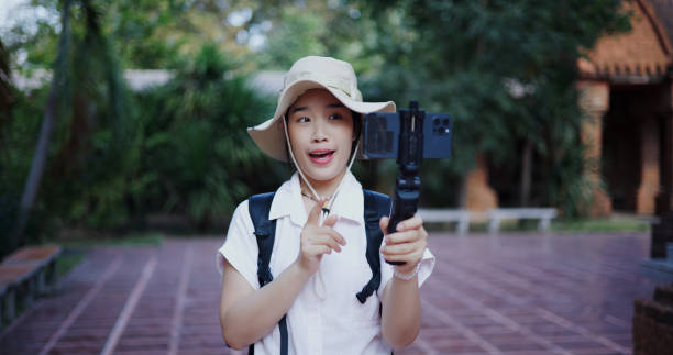 istock A female internet influencer tourist is using mobile phone to vlogging or live streaming on social media while walking around an ancient temple. 2191550475