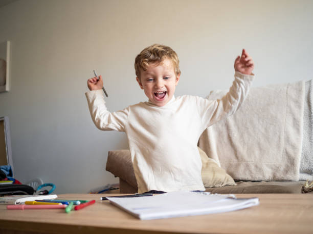 istock Happy child celebrating success while learning at home 2191550502