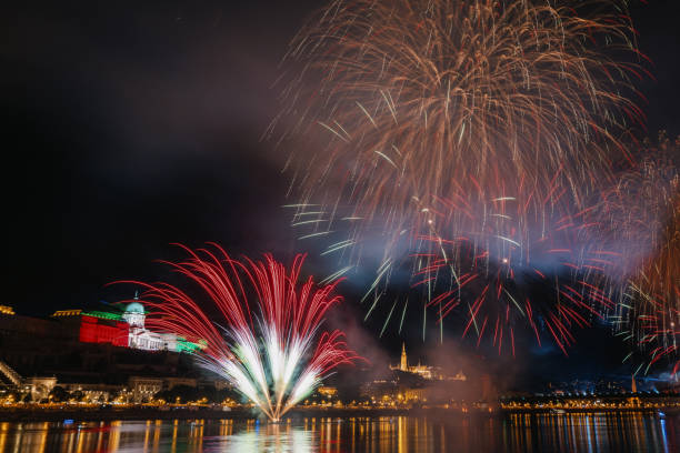 Colorful fireworks illuminate the night sky over Budapest on August 20th. The festive display celebrates the city\\'s rich history and culture, reflected in the Danube River.