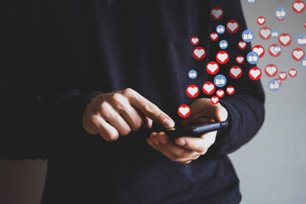 istock Man holds a phone and send likes, hearts as a feedback. 2191551183