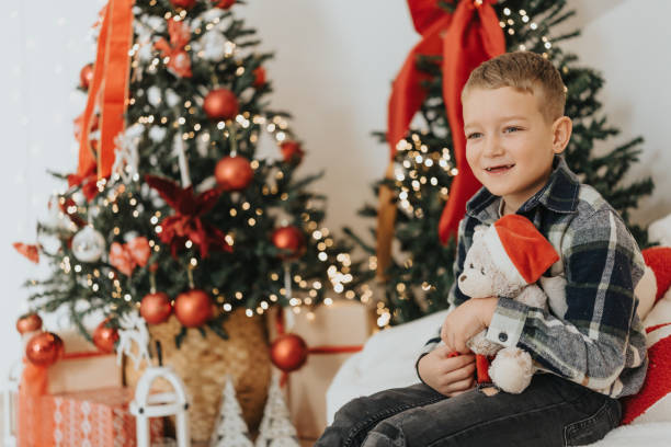istock Cheerful boy getting ready for opening Christmas presents at home 2191554180