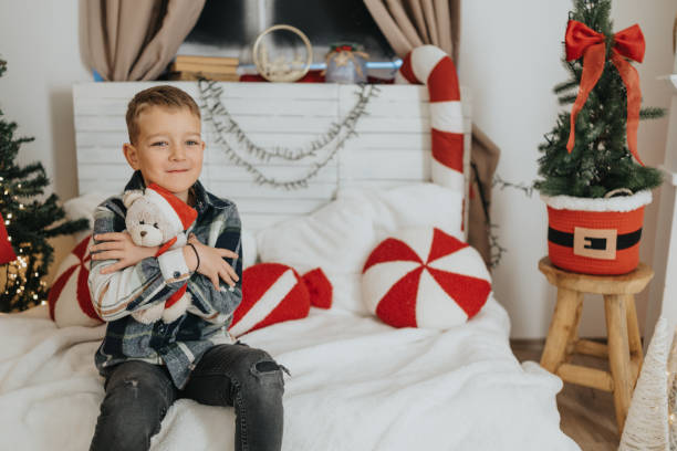 istock Cheerful boy getting ready for opening Christmas presents at home 2191554321
