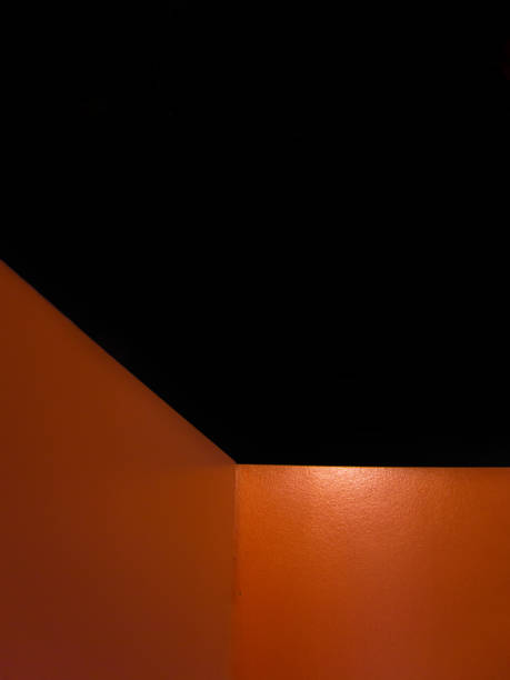 A black and orange wall with a corner. The wall is made of wood. The corner is cut off