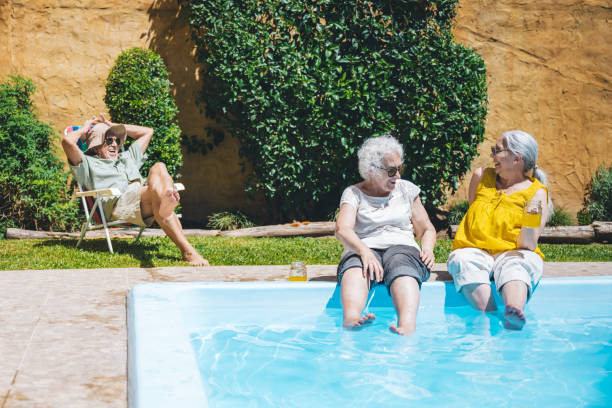 istock three happy seniors fooling around at swimming pool 2191560872