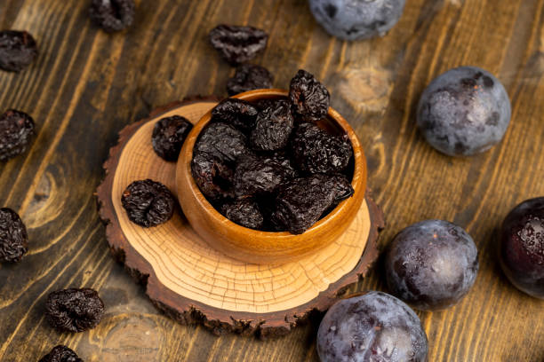 istock ripe purple plums and dried plums 2191565164