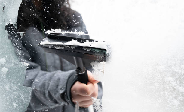 istock Driver is removing snow from car windshield with ice scraper and broom, clean car window from icy frost, winter season 2191567239