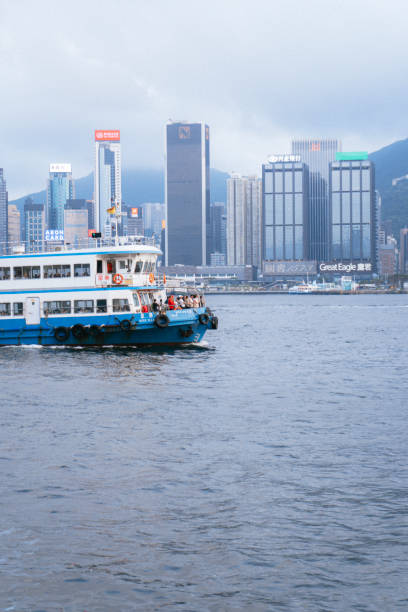 A stunning view of Hong Kong's iconic skyline with modern skyscrapers and Victoria Harbour in the foreground. The vibrant cityscape showcases the blend of urban development and natural beauty.
