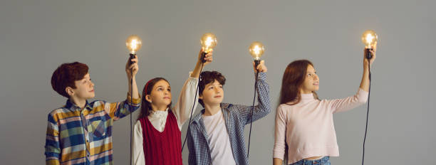 istock Kids holding glowing light bulbs as metaphor for developing their own creative ideas 2191571169
