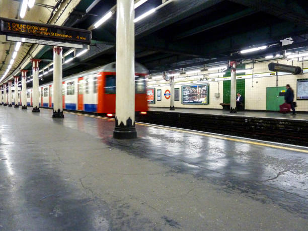 London Underground train zooming through Temple subway station