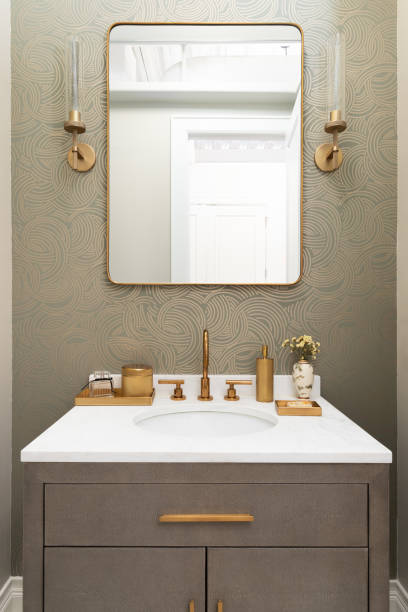 istock A bathroom detail with a pattern wallpaper and gold accents. 2191574590