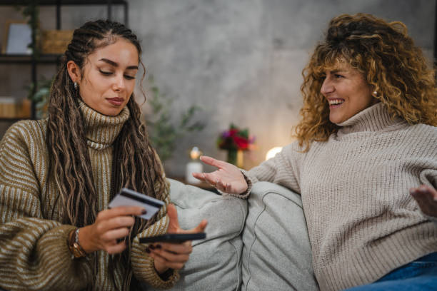 istock two friendly women use cellphone and credit card make payments online 2191575700