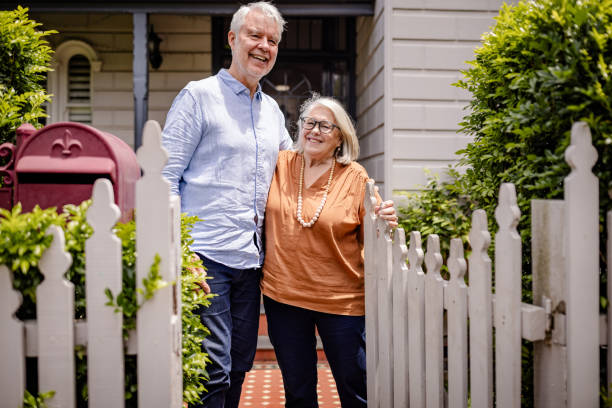 istock Smiling elderly couple posing in front of their home. 2191575875