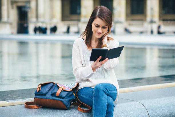 istock Young woman reading e-book in the city 2191575902