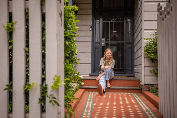istock Woman sitting on front porch with a peaceful smile 2191576900