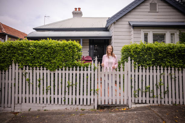 istock Woman standing behind white picket fence calmly 2191576956