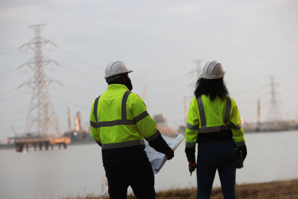 istock A man and a woman, both engineers, wear green safety jackets while working at a renewable energy facility focused on producing clean, environmentally friendly power with no carbon emissions. 2191577167