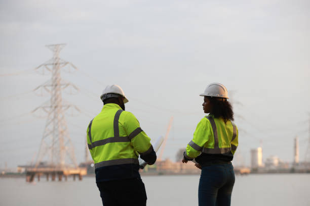 istock A man and a woman, both engineers, wear green safety jackets while working at a renewable energy facility focused on producing clean, environmentally friendly power with no carbon emissions. 2191577669