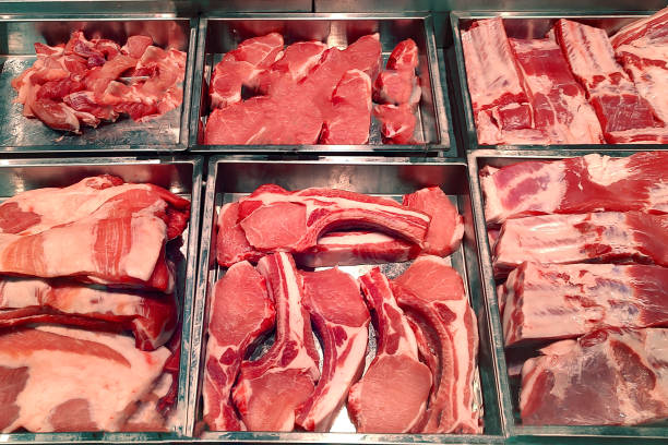 Butcher shop fridge counter with cold raw meat close up