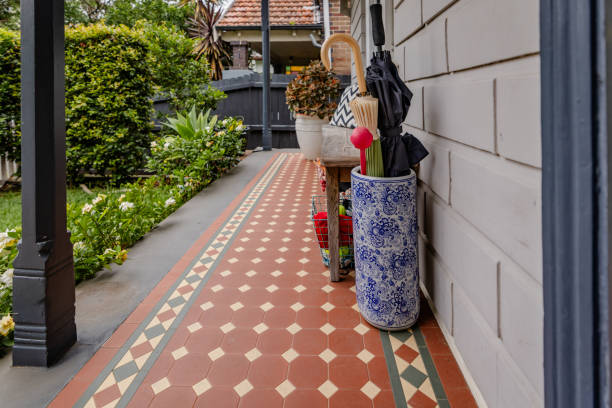 An inviting front porch area highlighted by decorative tiled flooring, decorative elements, and a well-kept pathway, reflecting a warm and welcoming home atmosphere.