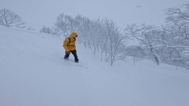 istock Snowboarder descending down a mountain forest freshly covered with powder snow 2191587295
