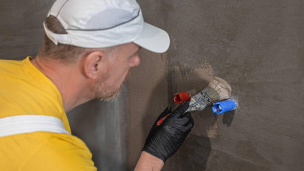 istock A worker's gloved hand applies a liquid membrane using a brush. Foolproof waterproofing under a tile bathroom. 2191587605