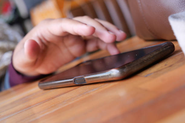 woman hand picking up smart phone mobile to receive a call .