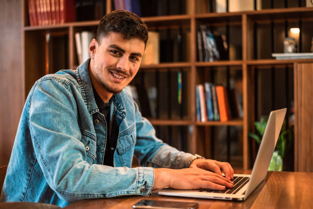 istock A happy male college student using a laptop in a university library or working in the office workplace. 2191593347