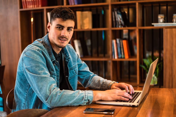 istock A happy male college student using a laptop in a university library or working in the office workplace. 2191593363