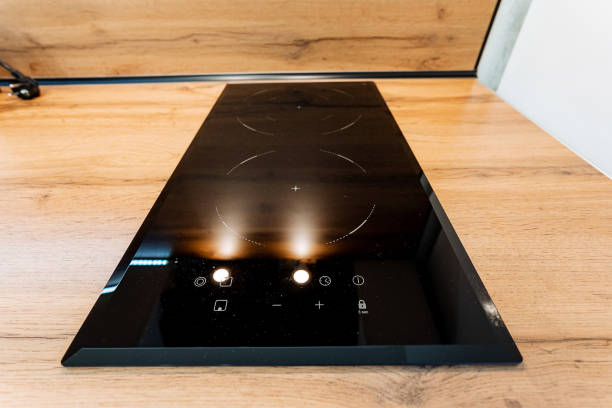 A sleek black stove top oven sits on a sturdy wooden countertop, enhancing the kitchens aesthetic and creating a stylish, functional area that inspires culinary creativity