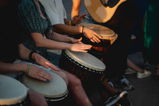 istock A lively group of people are enthusiastically playing drums while a talented man skillfully plays a guitar, creating an energetic atmosphere filled with delightful music and entertainment 2191594171