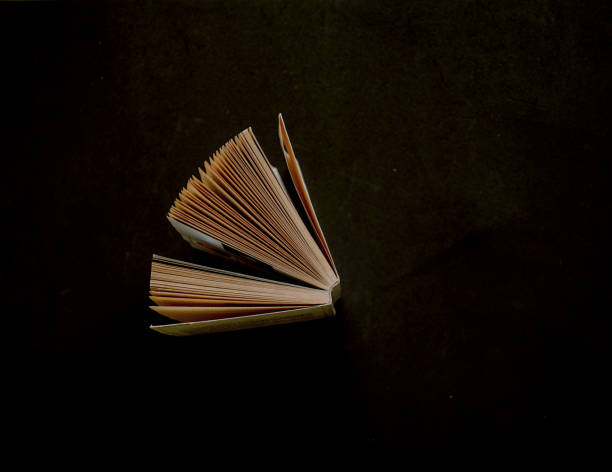 books open in a fan on black background