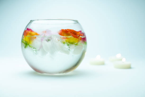 Flower heads of purple roses in a crystal vase on a table.