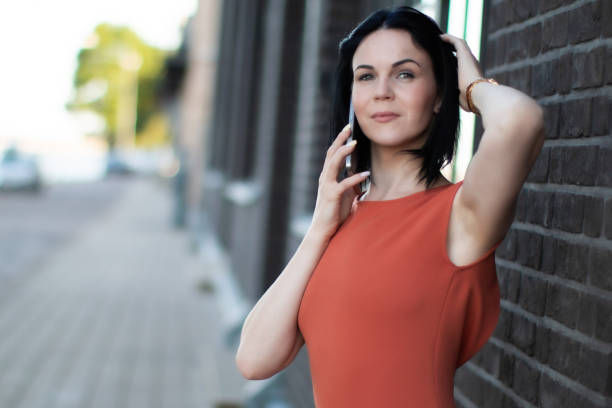 istock Confident woman talking on the phone in outdoors with a modern urban backdrop. 2191604184