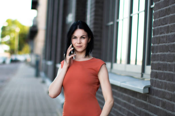 Confident woman talking on the phone in outdoors with a modern urban backdrop.