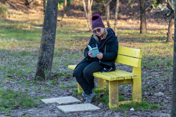 istock Woman reading on the bench 2191606459