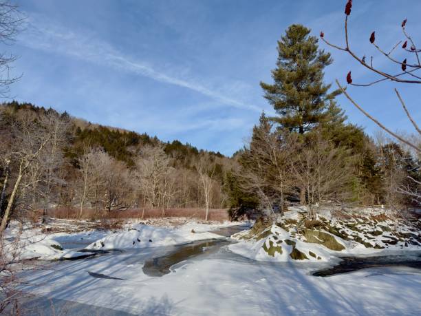 A rivers edge of a partially frozen Mad River in Vermont in Winter